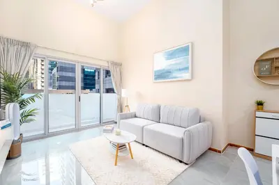 a living room with a white couch and a table at Perfect Marina Stay - Ideal for great Holidays in Dubai