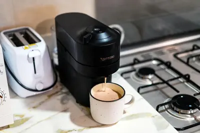 a coffee maker sitting on a stove with a cup of coffee at Perfect Marina Stay - Ideal for great Holidays in Dubai