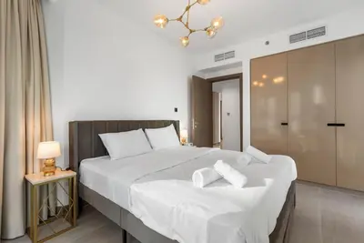a bedroom with a large bed with white sheets at LUX 2BR in Missoni Tower - 5 mins to Burj Khalifa in Dubai