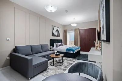 a living room with a couch and a bed at Newly Built Studio - Urban Living in Dubai