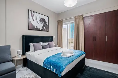 a bedroom with a bed and a chair and a window at Newly Built Studio - Urban Living in Dubai