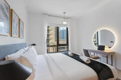 a bedroom with a bed and a desk with a laptop at Exquisite centrally located 1BR in Downtown Dubai in Dubai