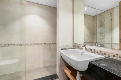 a bathroom with a sink and a mirror at NEW! Spacious 2BHK with Maids room - JVC in Dubai