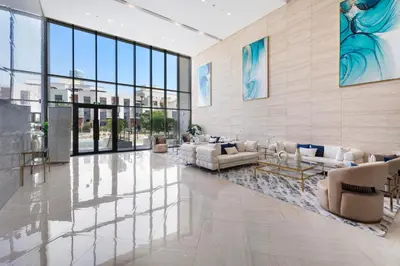 a lobby with white furniture and large windows at NEW! Spacious 2BHK with Maids room - JVC in Dubai