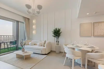 a white living room with a white couch and a table at Bright and Exquisite 1-Bedroom in Downtown views 2 in Dubai