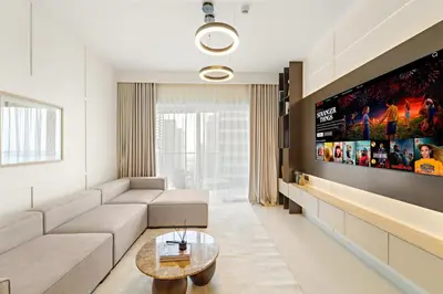 a living room with a couch and a flat screen tv at Elegant 2BR with Palm & Sea View l Direct Beach Access in Dubai