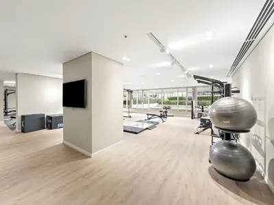 a gym with two exercise machines and a flat screen tv at Elegant 2BR with Palm & Sea View l Direct Beach Access in Dubai