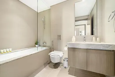 a bathroom with a tub and a toilet and a sink at Elegant 2BR with Palm & Sea View l Direct Beach Access in Dubai