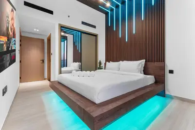 a bedroom with a large white bed and some lights at Full Dubai Skyline View LUX 1 BR JVC in Dubai