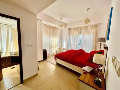 a bedroom with a red bed in a room at Bahar 6 in Dubai