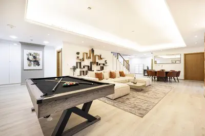 a living room with a pool table and a couch at Next'Living - Luxury Private Room in a Shared Villa in Dubai