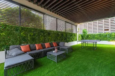 a patio with a couch and a table on the grass at Next'Living - Luxury Private Room in a Shared Villa in Dubai