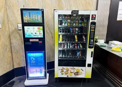 a drink vending machine with a tablet next to it at Familiar Partition Room In Tecom Near ICM Metro in Dubai