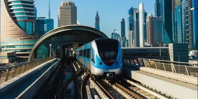 a blue and white train on the tracks in a city at The Junction Partition Room In Barsha Heights in Dubai