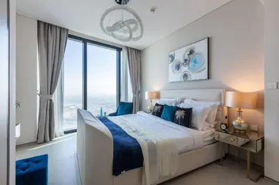 a bedroom with a large bed and a large window at Elegant 2BR Apt Address Beach Resort in Dubai