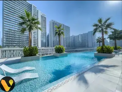 a pool on the roof of a building with palm trees at Vogue Downtown The Sterling by Omniyat, near Burj Khalifa and Dubai Mall, Studio Apartment with Balcony and Access to all Amenities in Dubai