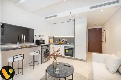 a living room with a couch and a table at Vogue Downtown The Sterling by Omniyat, near Burj Khalifa and Dubai Mall, Studio Apartment with Balcony and Access to all Amenities in Dubai