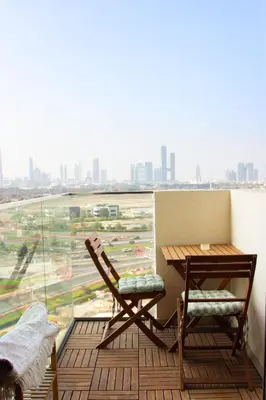 a balcony with a table and a chair and a window at Modern Studio 15mins away From World Trade Center in Dubai