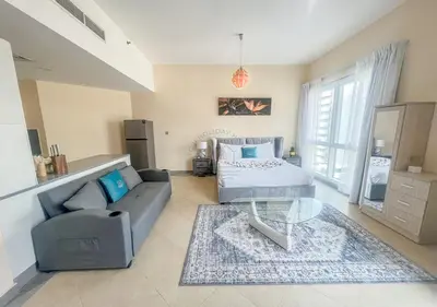 a living room with a couch and a table at Snug Studio With City Views, Perfect For Couples in Dubai