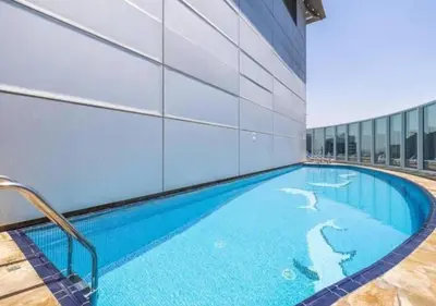 a swimming pool in the side of a building at Snug Studio With City Views, Perfect For Couples in Dubai