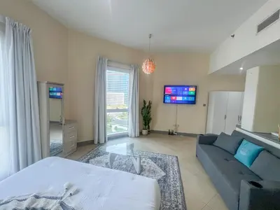 a living room with a bed and a couch at Snug Studio With City Views, Perfect For Couples in Dubai
