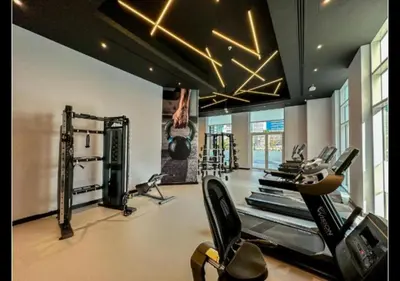 a gym with several treadmills and cardio machines at Snug Studio With City Views, Perfect For Couples in Dubai