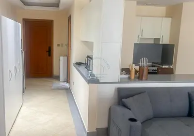 a living room with a couch and a kitchen at Snug Studio With City Views, Perfect For Couples in Dubai