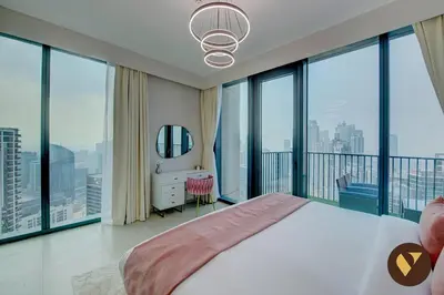 a bedroom with a large bed and large windows at Vogue Downtown Boulevard Heights near Dubai Mall and Burj Khalifa, Two Bedroom Apartment with balcony and Access to all Amenities in Dubai