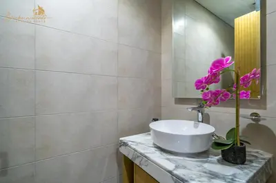 a bathroom with a sink and a flower on a counter at CHIC Sea View 2Bhk 4pax in Dubai