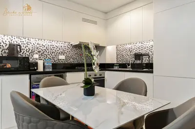 a white kitchen with a table and chairs at Exclusive Sea-View 3Bhk 6pax in Dubai