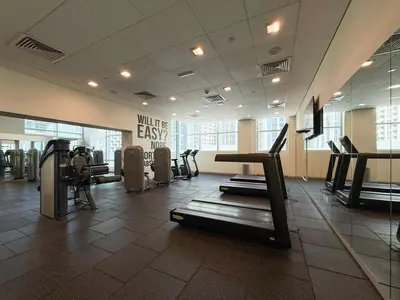 a gym with several treadmills and machines in a room at Beautiful 2 BR Apartment next to Opera I Burj View in Dubai