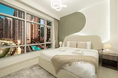 a bedroom with a large window with a view of a city at Beautiful 2 BR Apartment next to Opera I Burj View in Dubai