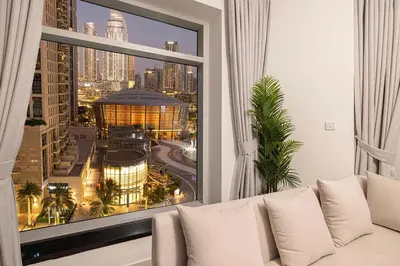 a white couch in a room with a large window at Beautiful 2 BR Apartment next to Opera I Burj View in Dubai