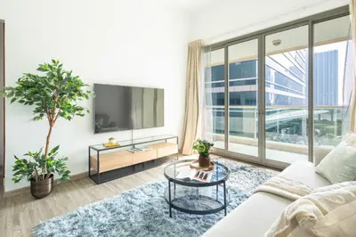 a living room with a white couch and a large window at Frank Porter - Marina Park in Dubai