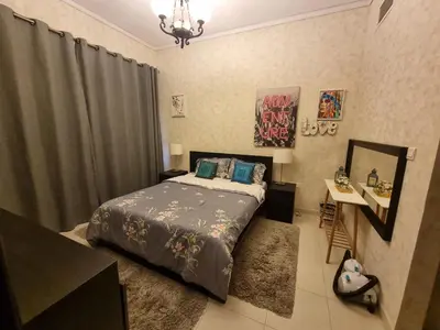 a bedroom with a bed and a table and a mirror at The One by Anu in Dubai