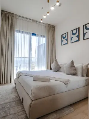 a large bed in a bedroom with a large window at EasyGo- Peaceful 1BDR in Binghatti Heights JVC-01 in Dubai