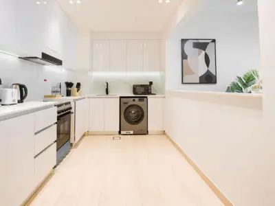 a kitchen with white cabinets and a washing machine at EasyGo- Peaceful 1BDR in Binghatti Heights JVC-01 in Dubai