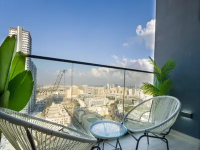 a balcony with two chairs and a view of a city at EasyGo- Peaceful 1BDR in Binghatti Heights JVC-01 in Dubai