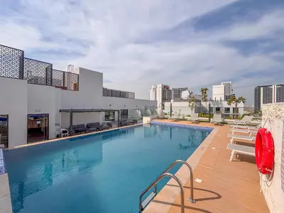a large swimming pool with chairs and a building at Frank Porter - Rokane G25 in Dubai