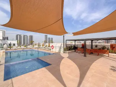 a swimming pool with a large umbrella on top of a building at Frank Porter - Rokane G25 in Dubai