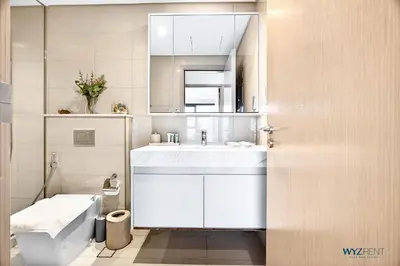 a bathroom with a white sink and a toilet at Sleek 1BR w Canal Views Next to Dubai Mall in Dubai