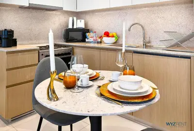 a kitchen with a table with plates and glasses on it at Sleek 1BR w Canal Views Next to Dubai Mall in Dubai