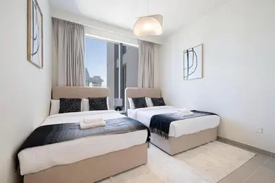 a hotel room with two beds and a window at LUXE - 2BR - Sea & City View - 5 Min to Dubai Mall in Dubai