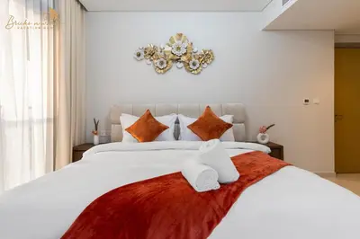 a bedroom with a large white bed with orange pillows at Glorious Sea View 3Bhk 6pax in Dubai