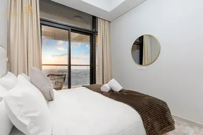 a bedroom with a white bed and a mirror at Glorious Sea View 3Bhk 6pax in Dubai