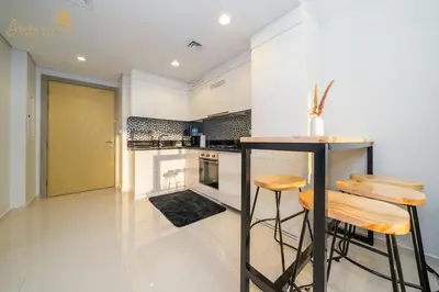 a kitchen with a counter and some stools in it at Sea & Sunset View 2Bhk 5pax in Dubai