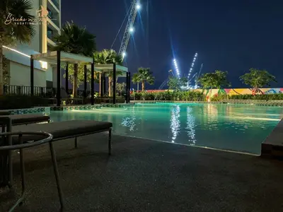 a large swimming pool at night with lights at Sea & Sunset View 2Bhk 5pax in Dubai
