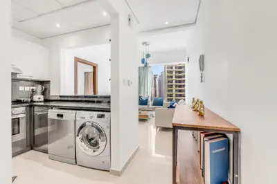 a kitchen with a washer and dryer and a table at Dubai Marina Elegant 1 BR on the Canal in Dubai
