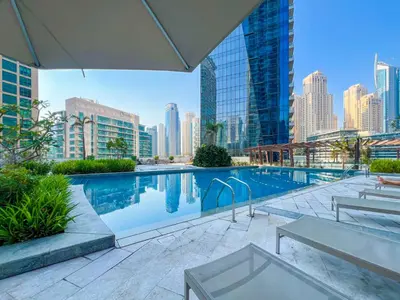 a swimming pool with a city skyline in the background at Dubai Marina Elegant 1 BR on the Canal in Dubai