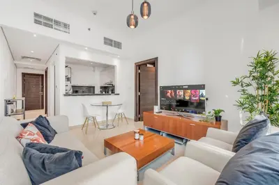 a living room with white furniture and a flat screen tv at Dubai Marina Elegant 1 BR on the Canal in Dubai